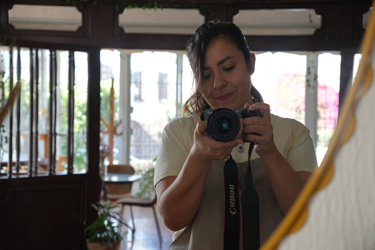 Mariana tomando una fotografía frente al espejo de la casa